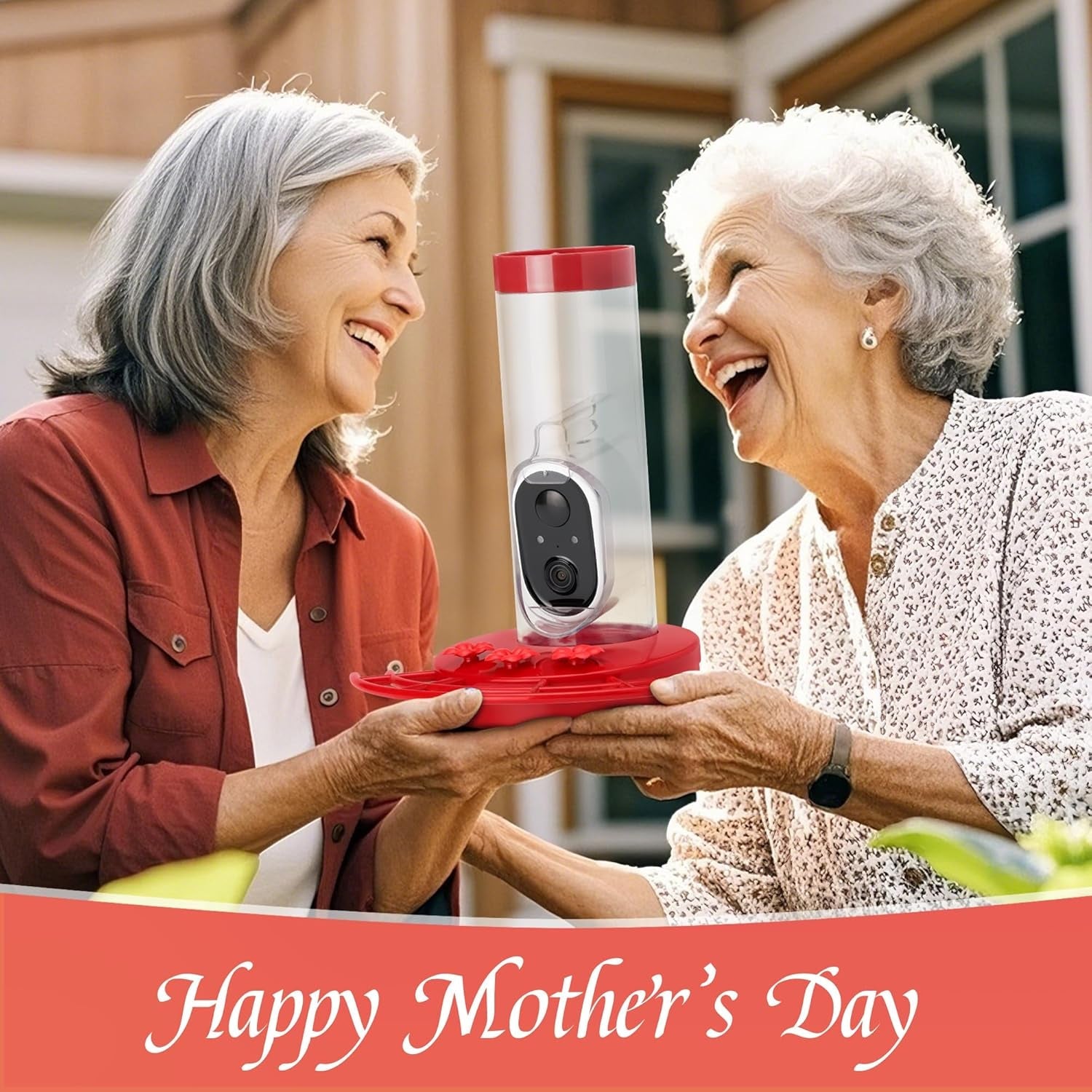 Red hummingbird feeder with solar camera held by two smiling women