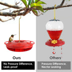 Red hummingbird dish feeder hanging from a branch with hummingbirds feeding