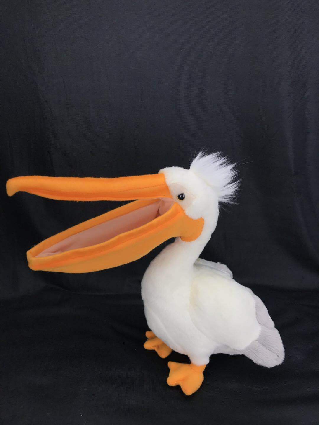 White plush pelican toy with extra-long orange beak, orange feet, and soft wings