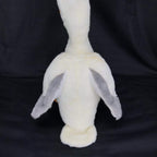 White plush pelican toy with gray wing tips and dangling orange feet, front-facing