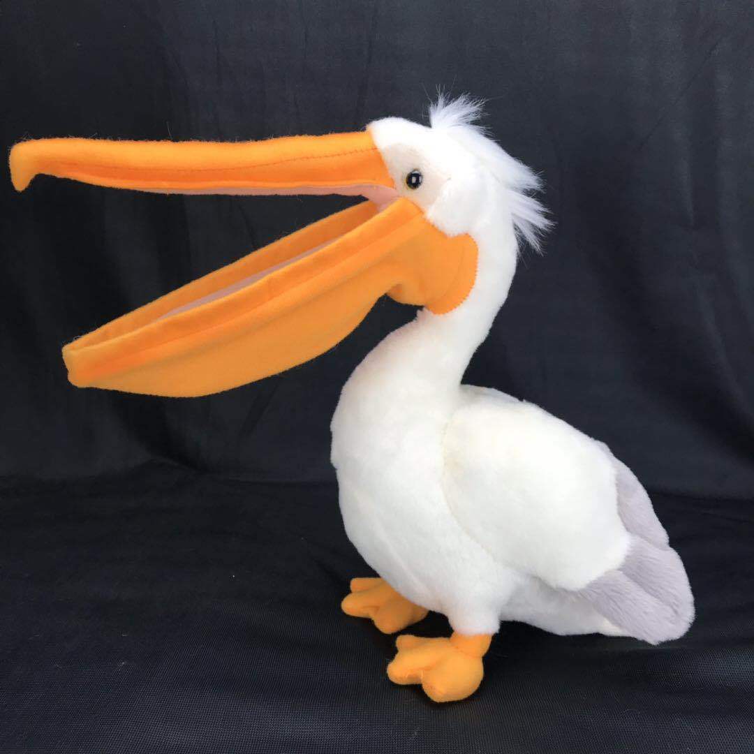 White plush pelican toy in side profile with extra-long orange beak and orange feet