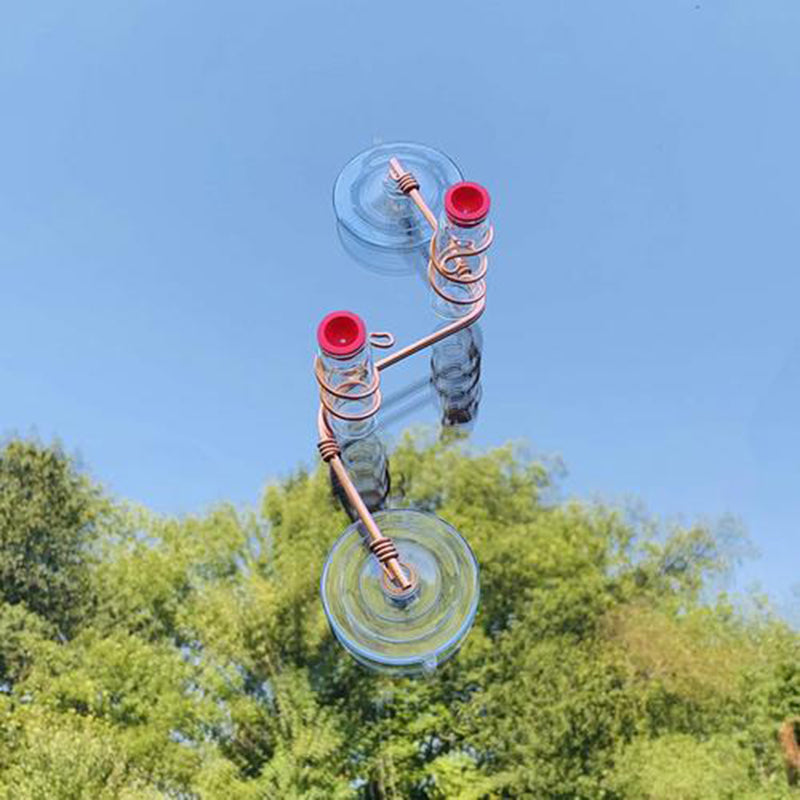 Copper wire hummingbird feeder with red cups and clear suction discs