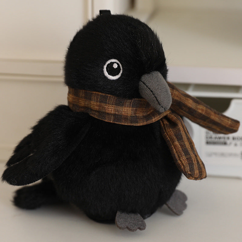 Black bird plush with white eye patch and plaid scarf, 13 cm