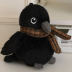 Black bird plush with white eye patch and plaid scarf, 13 cm