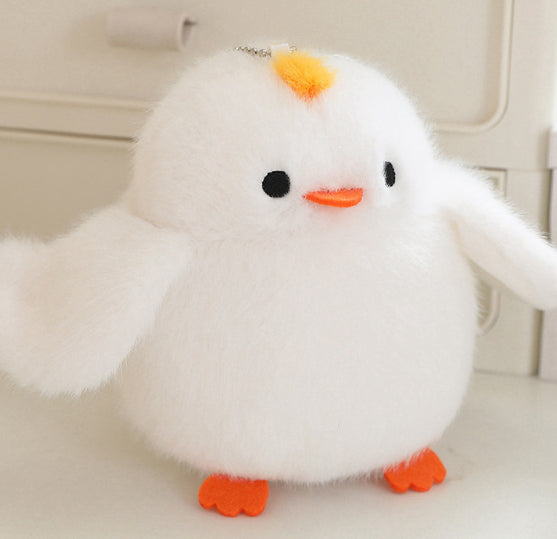 White plush chicken-style bird with orange beak, orange feet, and necklace