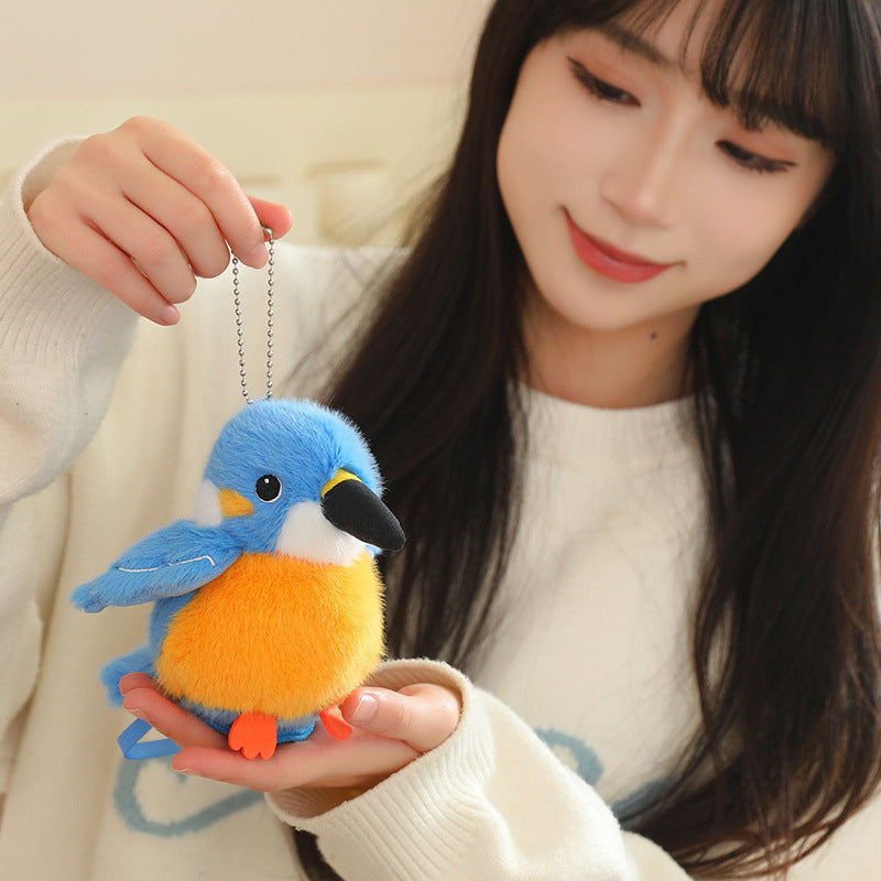 Blue and orange budgerigar plush bird on a chain, held in hands