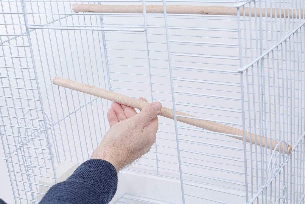 Person adjusting a wooden perch inside a white wire bird cage