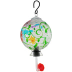 Hanging hand-painted glass hummingbird feeder with green vines and orange-red flower