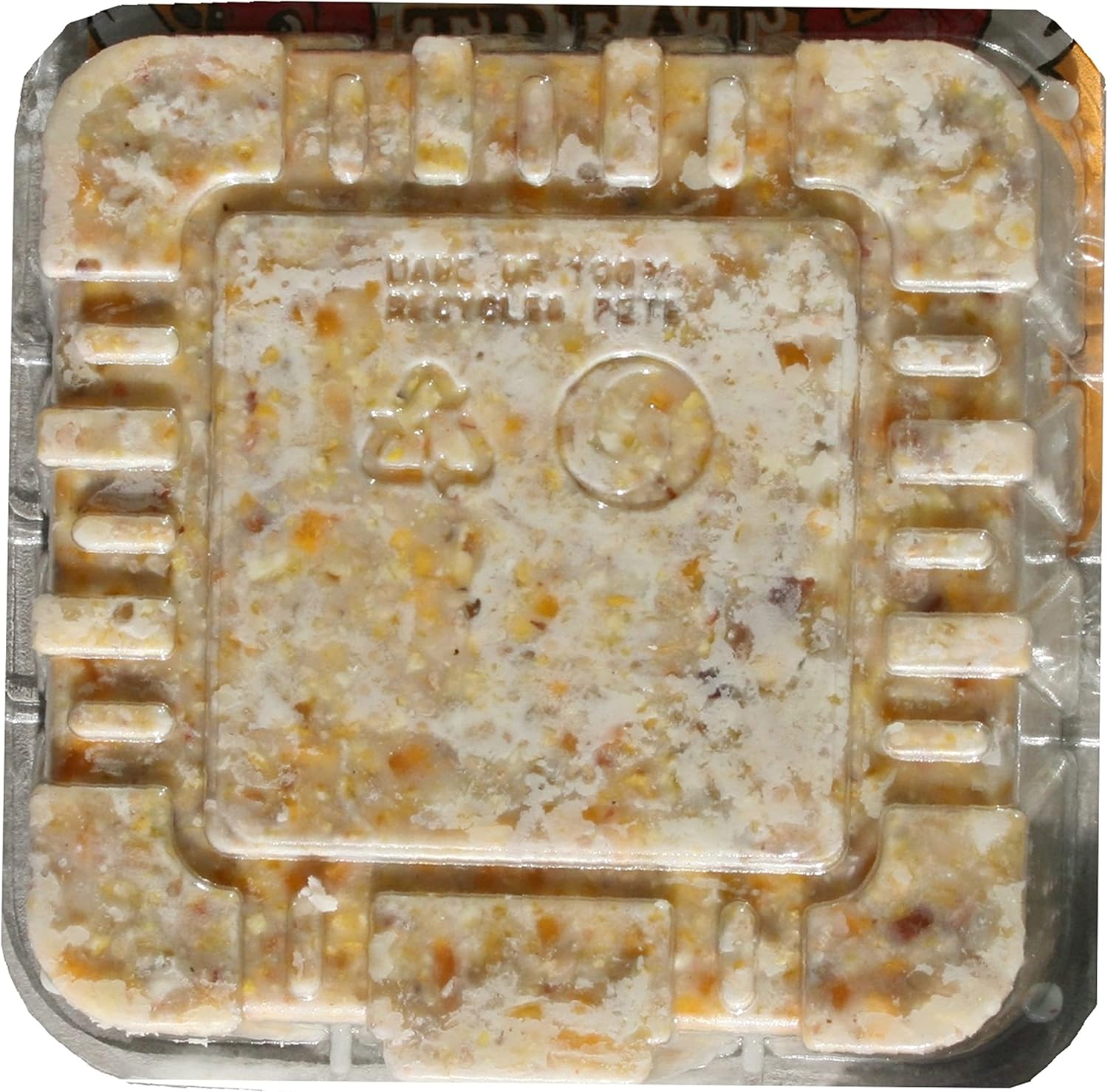 Square wild bird suet cake in plastic tray, textured golden-brown surface