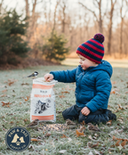 Alligator Brand wild bird food bag in child’s hands, orange stripes and bird house graphic