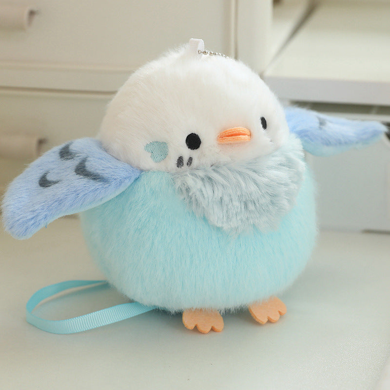 Light blue and white plush bird with orange beak, orange feet, and blue strap
