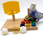 Wooden tabletop parrot activity center with yellow ring launcher, rings, pegs, and white balls