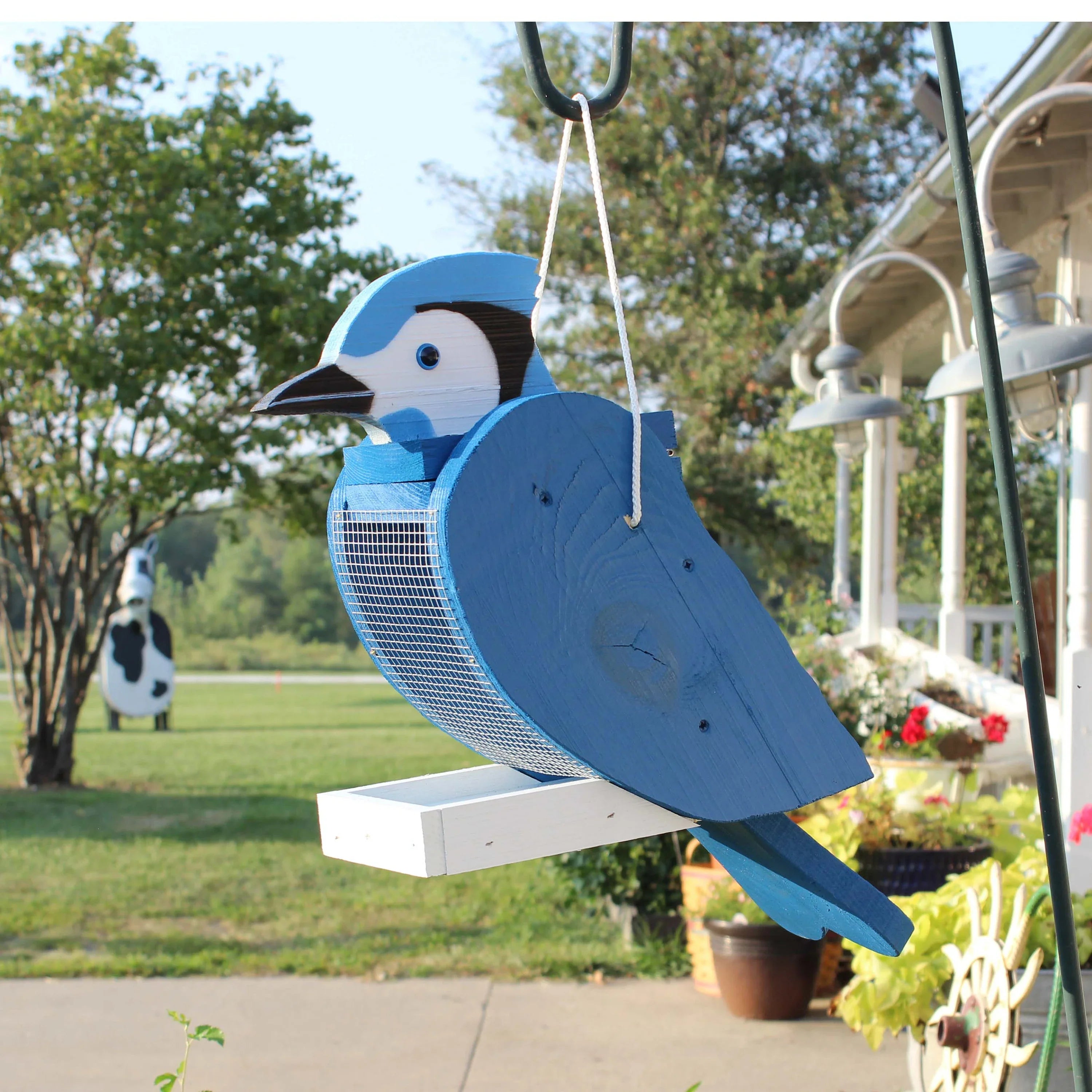 Blue wooden hanging wild bird feeder with mesh basket and perched songbird shape