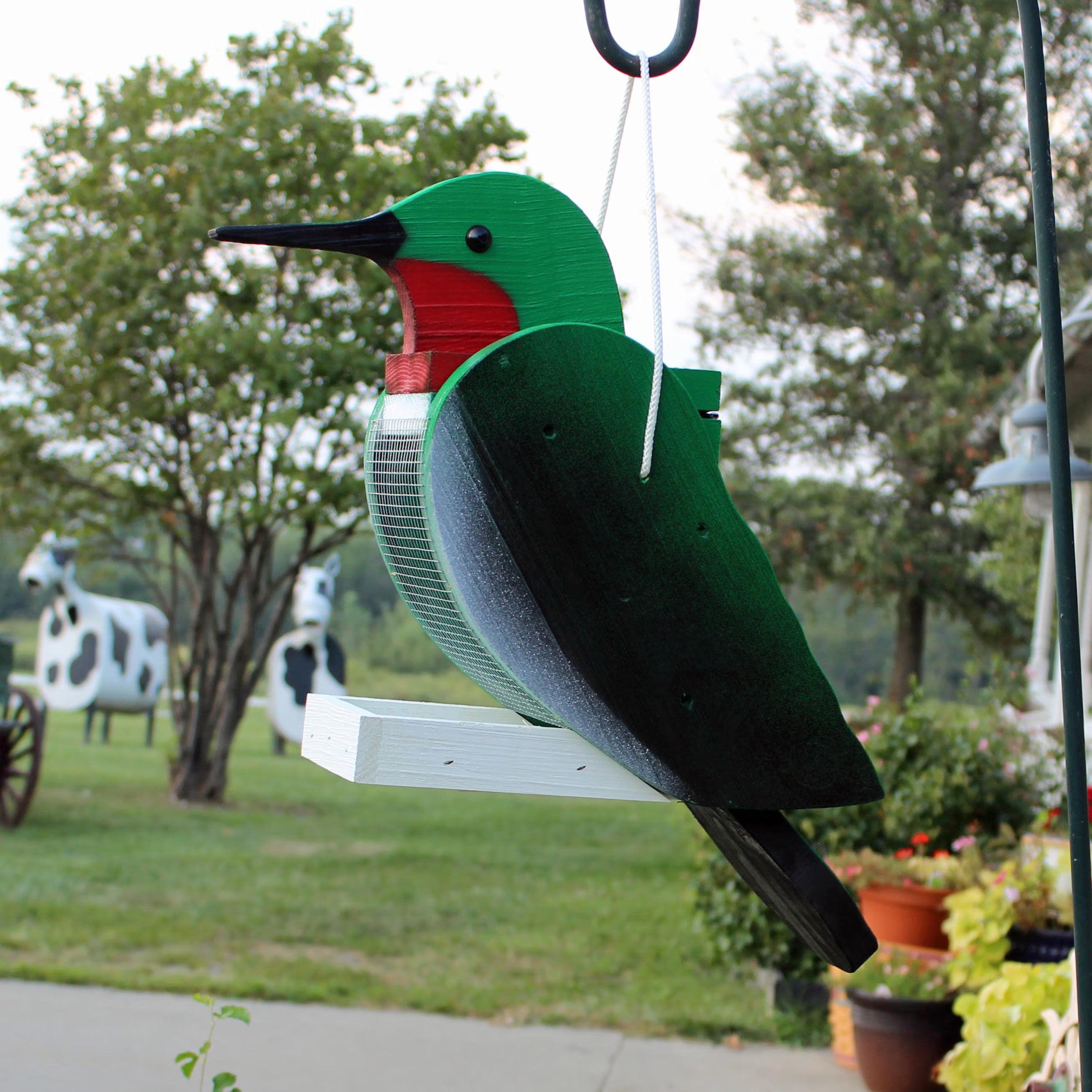 Green and red wooden hanging wild bird feeder with mesh basket and bird cutout