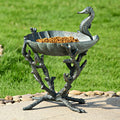 Cast aluminum seahorse birdbath with raised basin, filled with orange birdseed