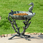 Cast aluminum seahorse birdbath with raised basin, filled with orange birdseed